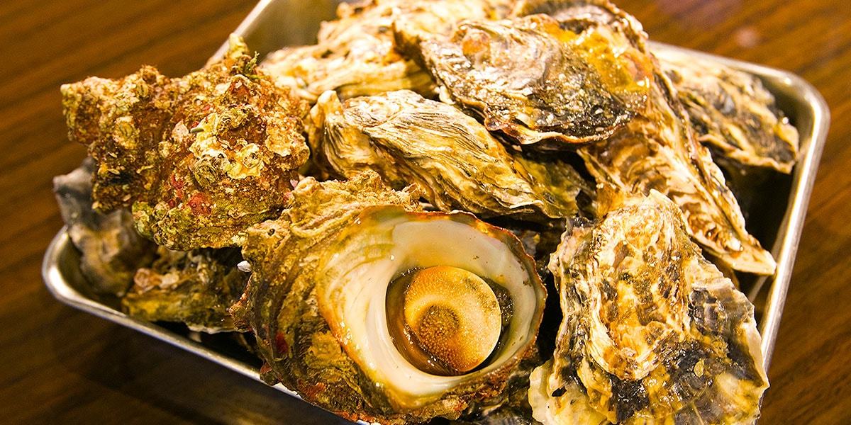 新鮮な牡蠣とサザエが、カゴいっぱいに入っています。博多の旬の海鮮食材を堪能いただけます。