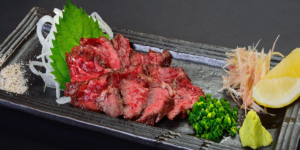 二階の座敷席の様子です。和紙を丸い提灯風にした電灯と、座布団を並べた卓席です。隣の席とは木製の小さな屏風で間仕切りしています。最大４０名ご一同でご利用いただけます。